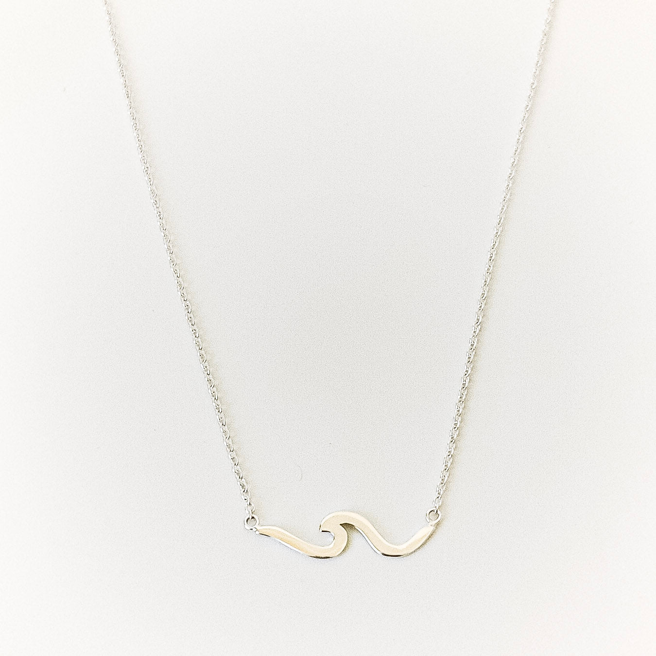 Necklace with a wave-shaped pendant on a light gray background