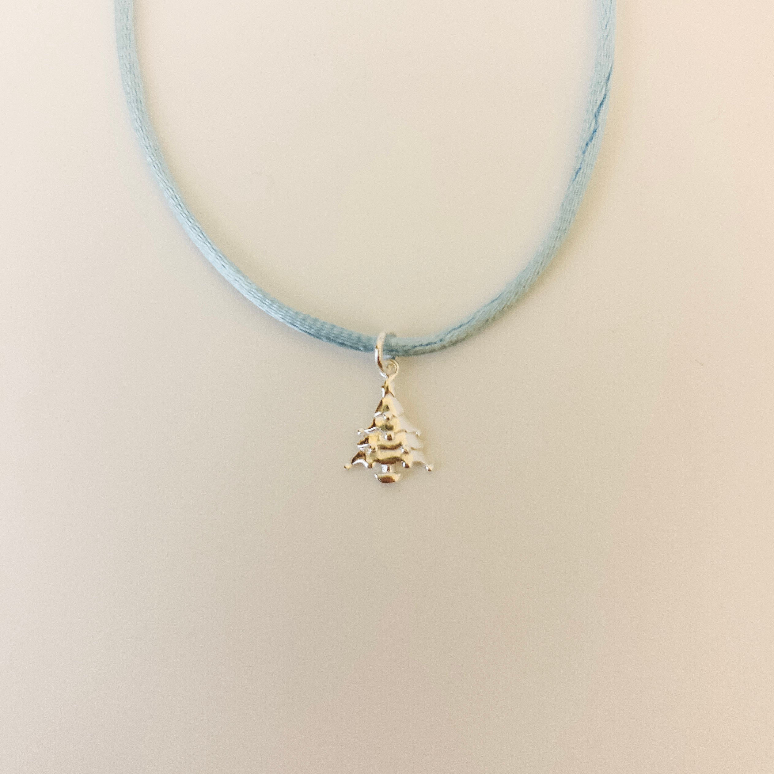 Necklace with a small pendant on a light beige background