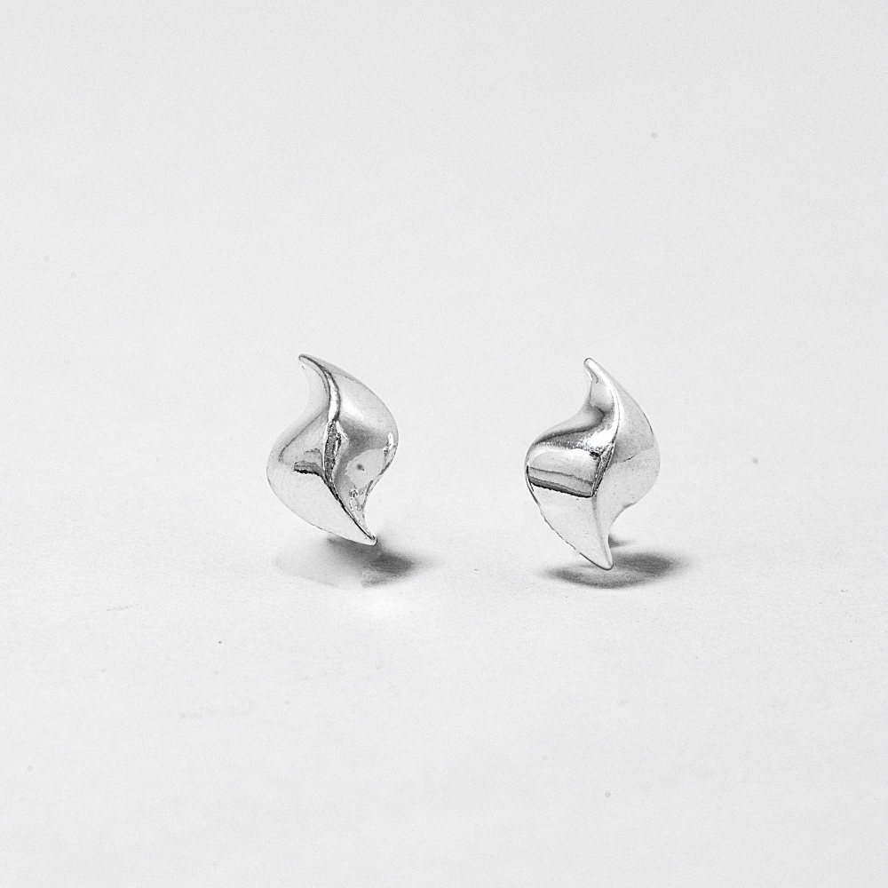 Pair of designer silver earrings on a grey background