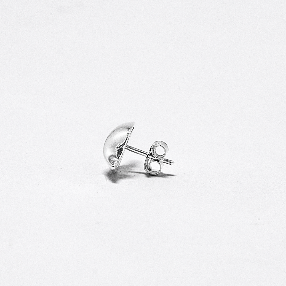 Silver earring on a light gray background