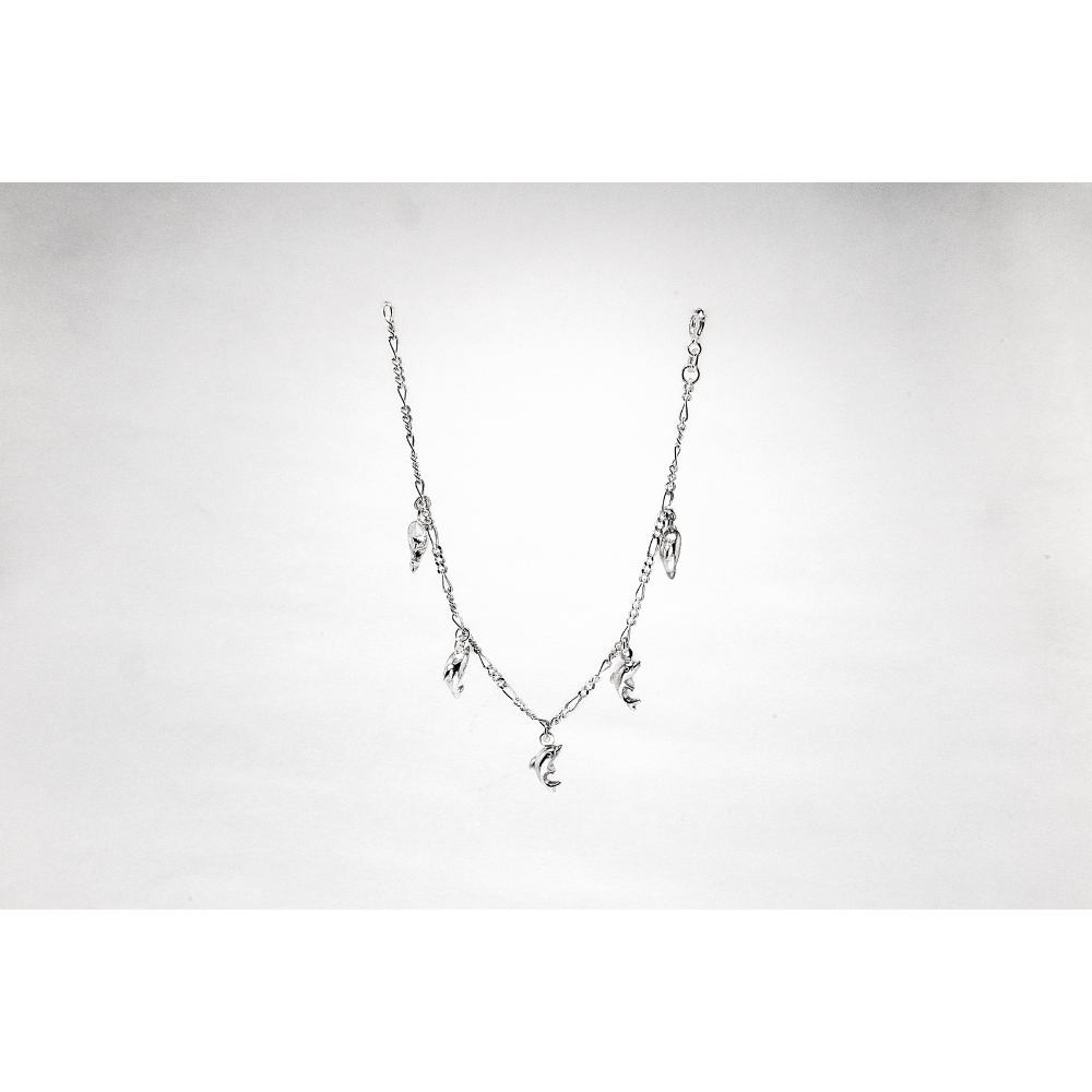 Silver necklace with letter pendants on a light grey background