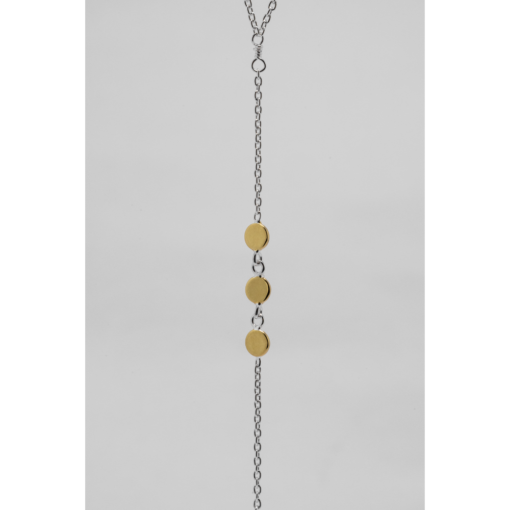 Necklace with gold disc pendants on a gray background