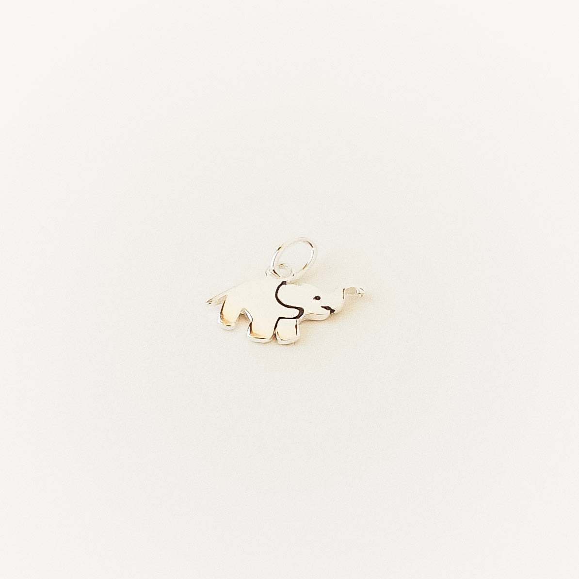 elephant charm on a light beige background