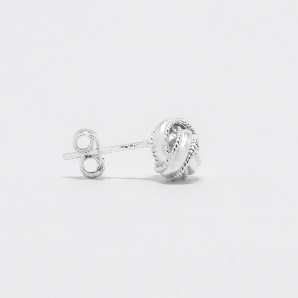 Silver earrings on a light gray background