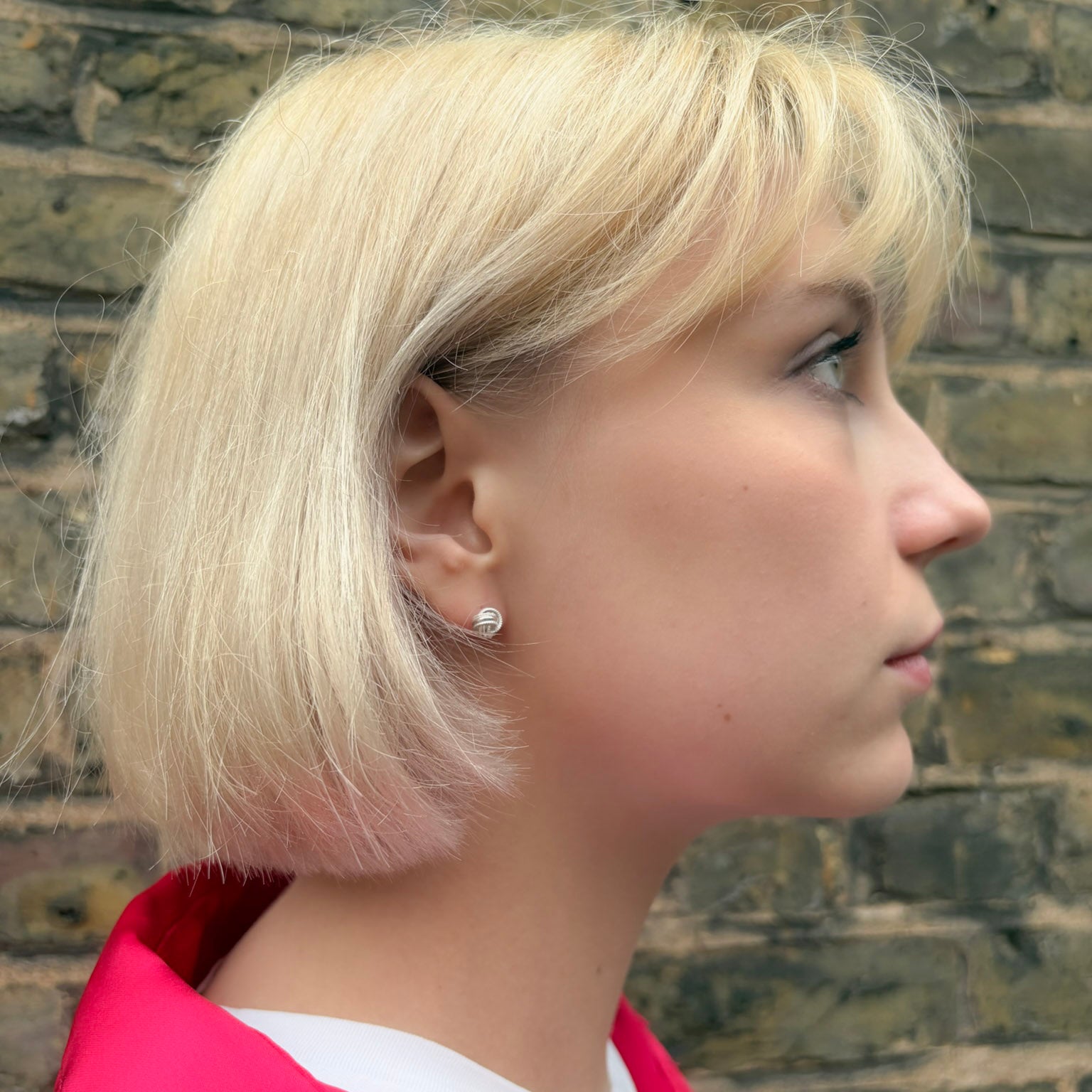 Profile of a person with blonde hair wearing pretty silver earrings
