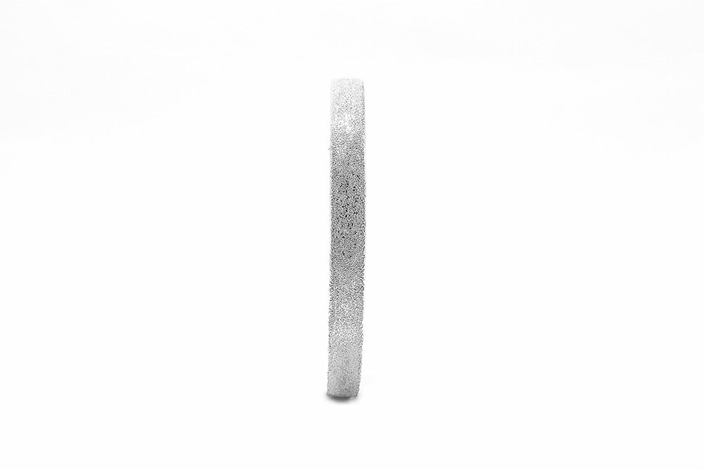 Silver ring with textured surface on a white background