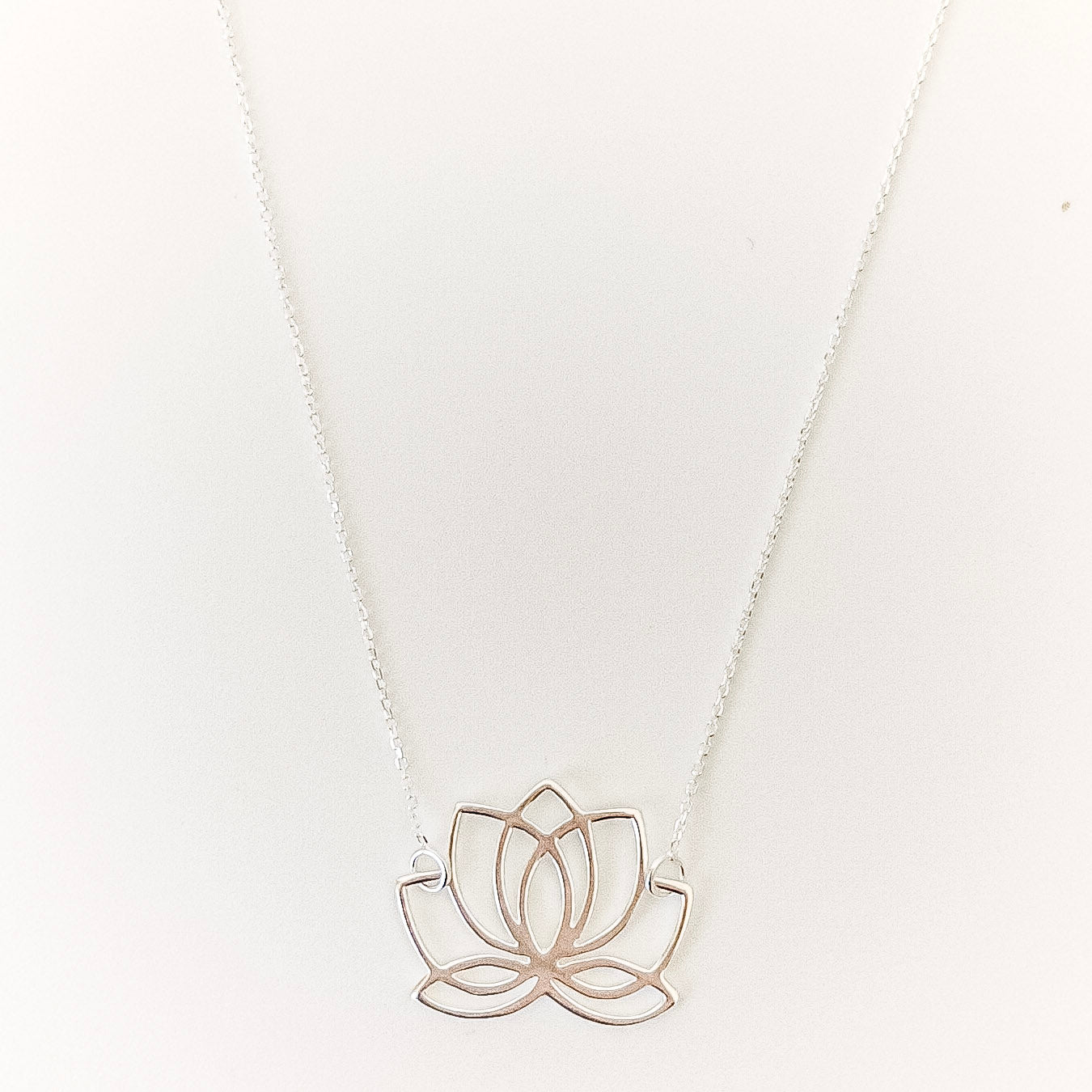 Silver lotus flower necklace on a white background
