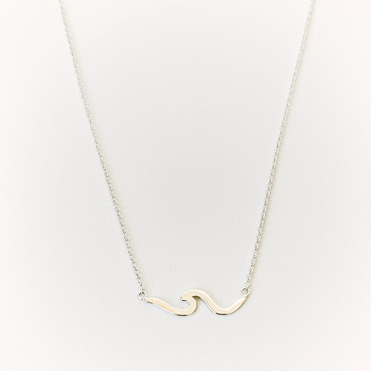 Necklace with a wave-shaped pendant on a light gray background