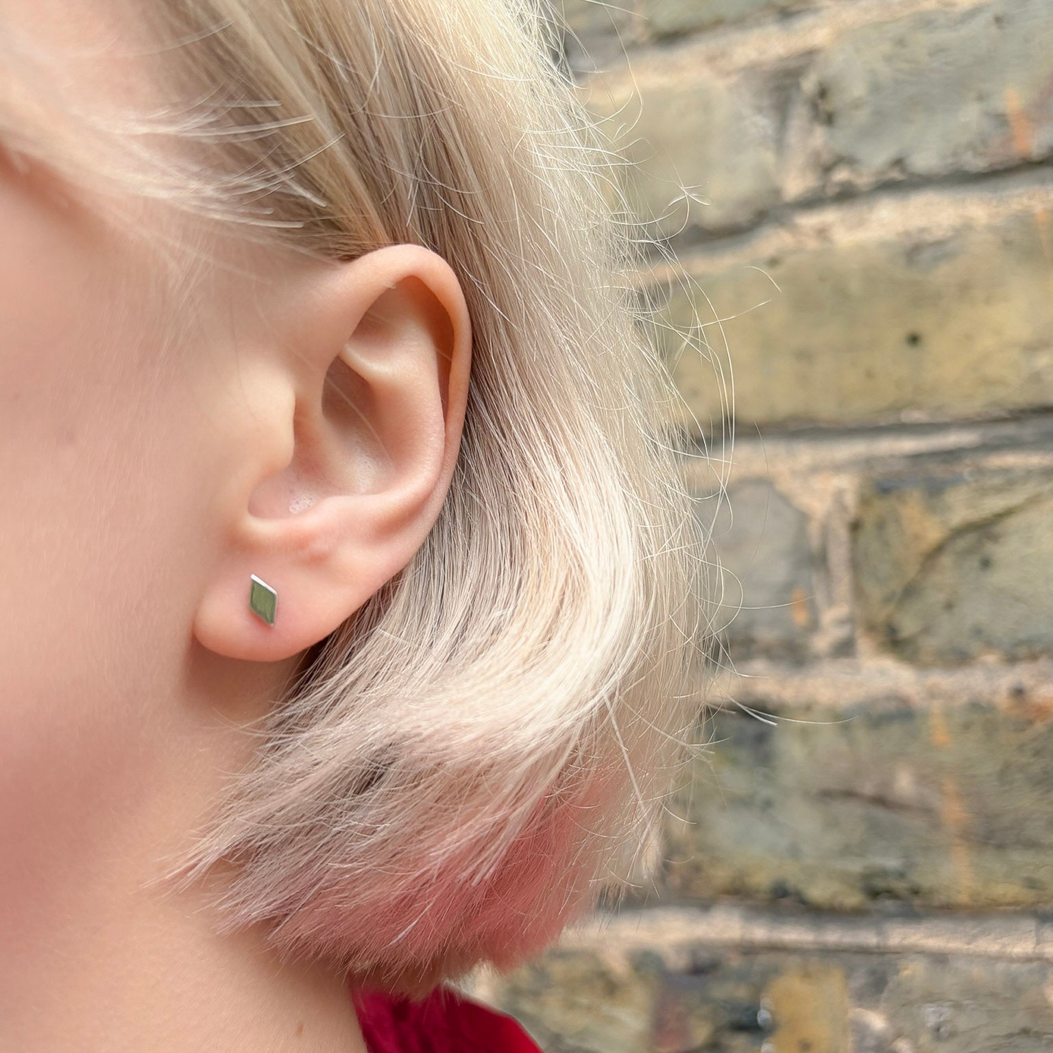 Close-up of an ear wearing a small diamond earring 