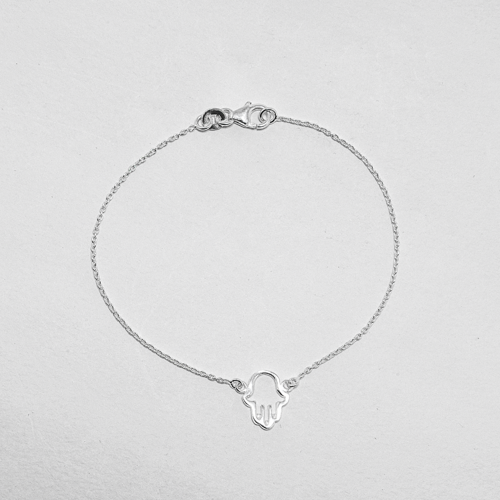 Silver bracelet with a Hamsa hand charm on a light background