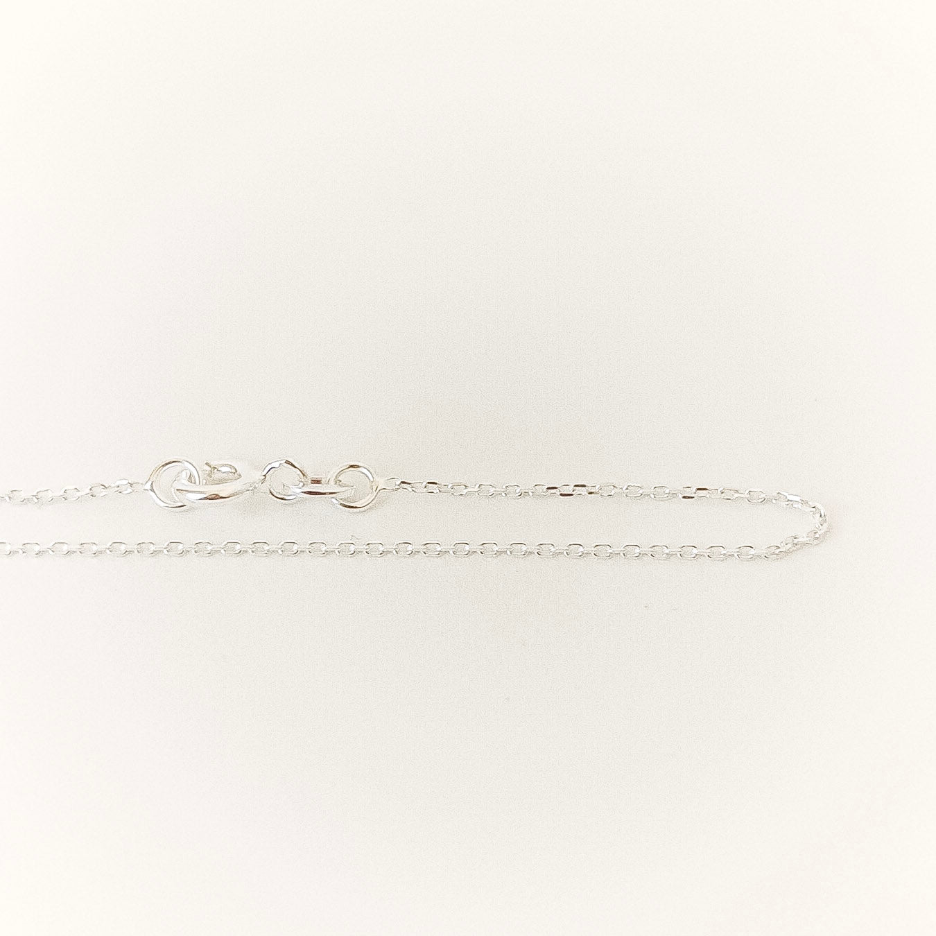 Silver bracelet on a light gray background