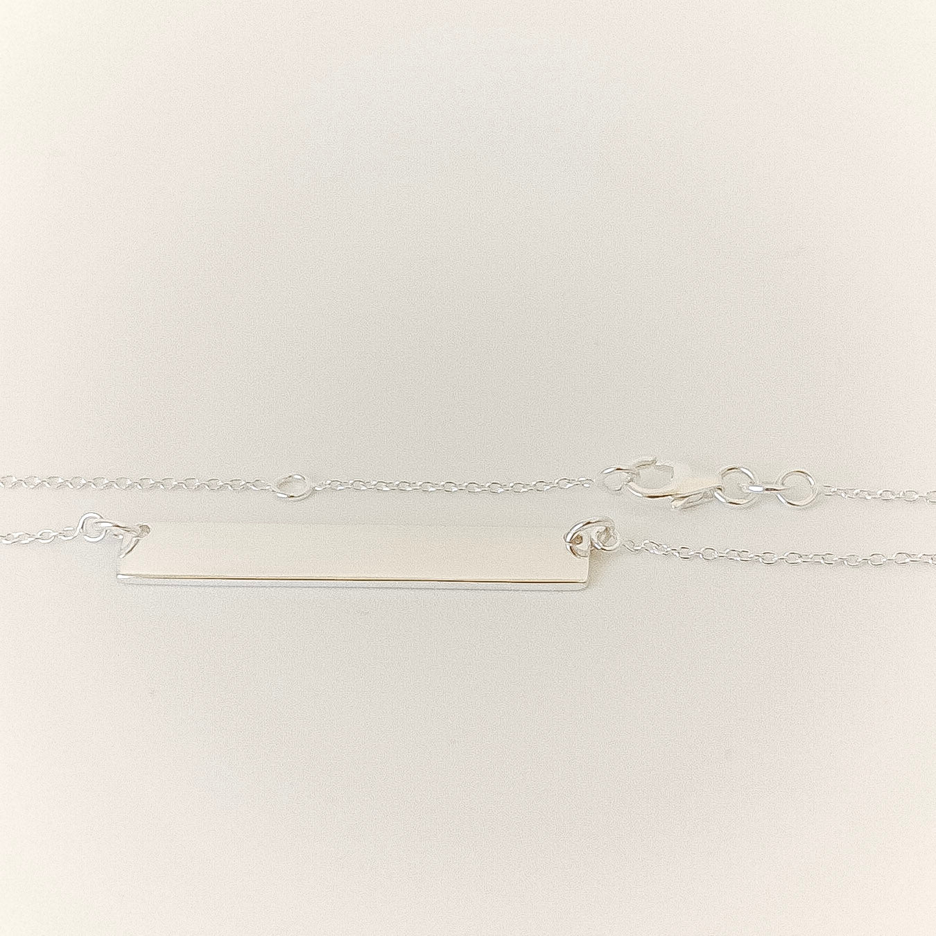 Silver bar necklace on a light gray background