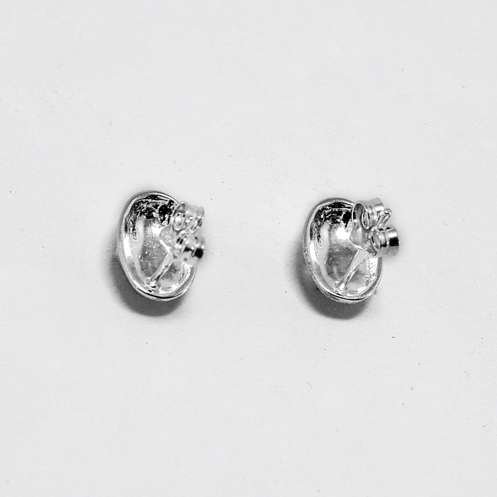 Pair of silver earrings on a light gray background