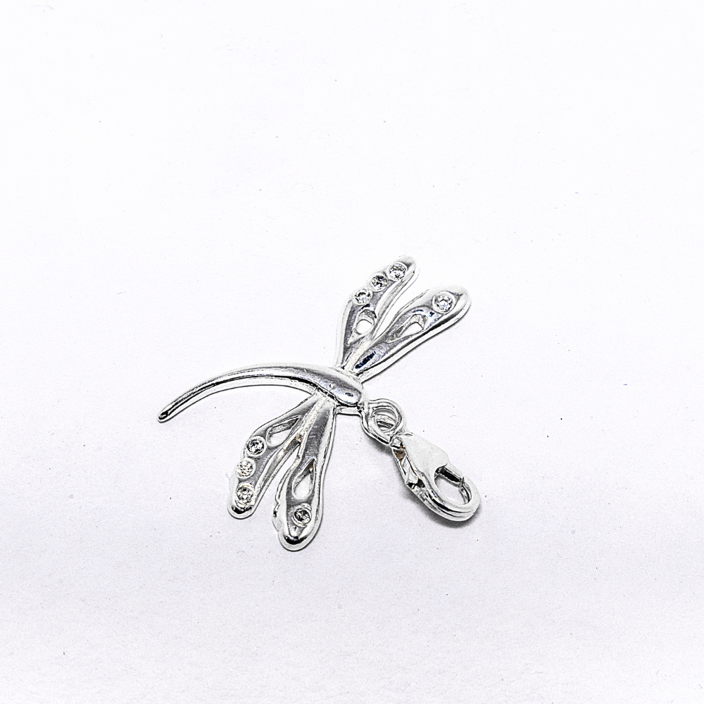 Silver dragonfly-shaped pendant on a white background