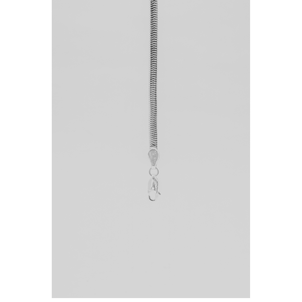 Silver chain bracelet on a light grey background