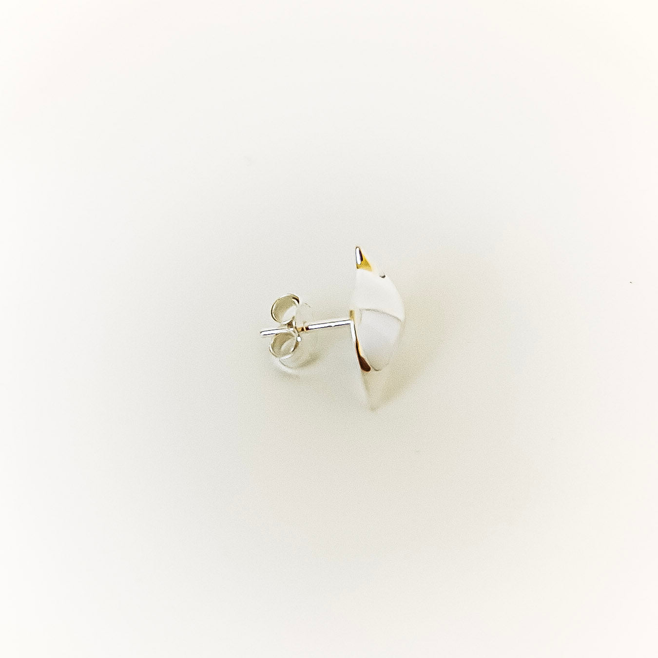 Single earring on a light beige background