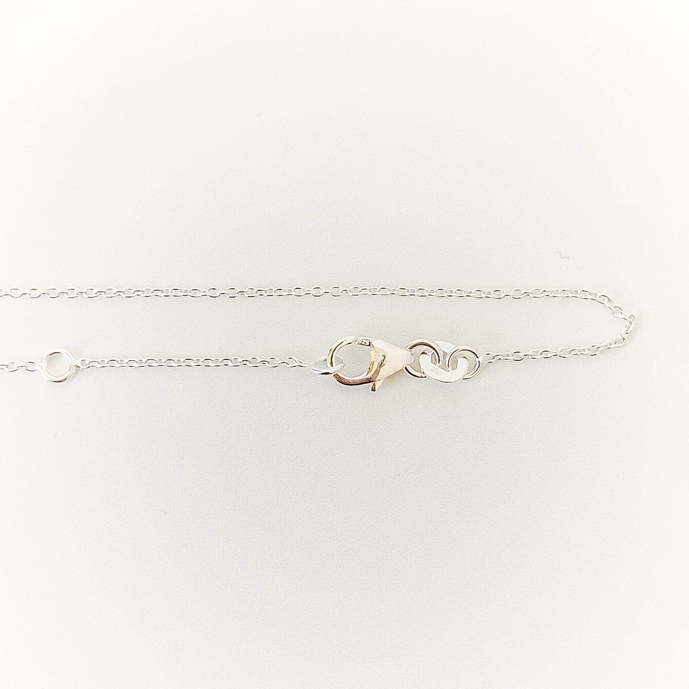 Silver bracelet with a clasp on a white background