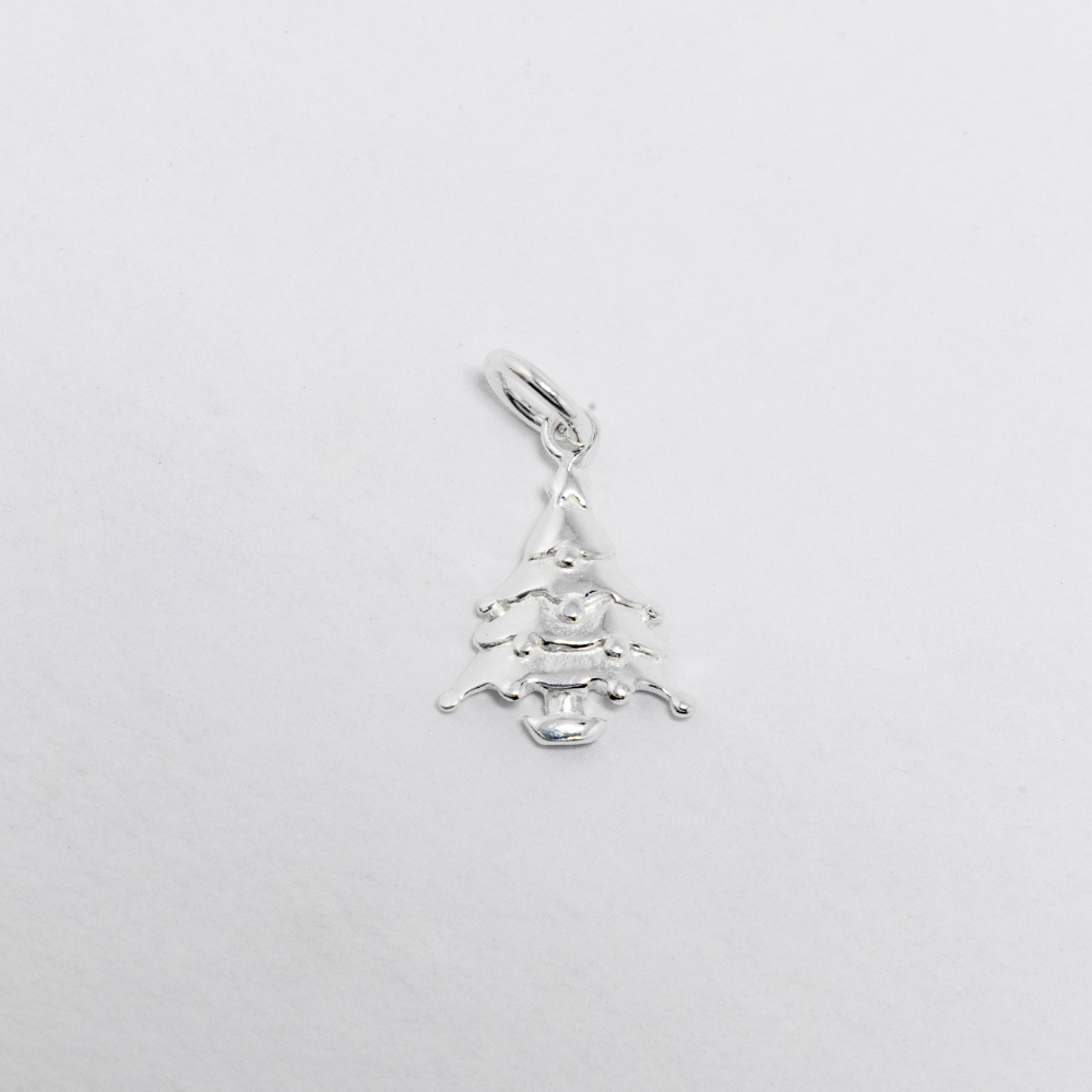 Silver tree charm on a light grey background