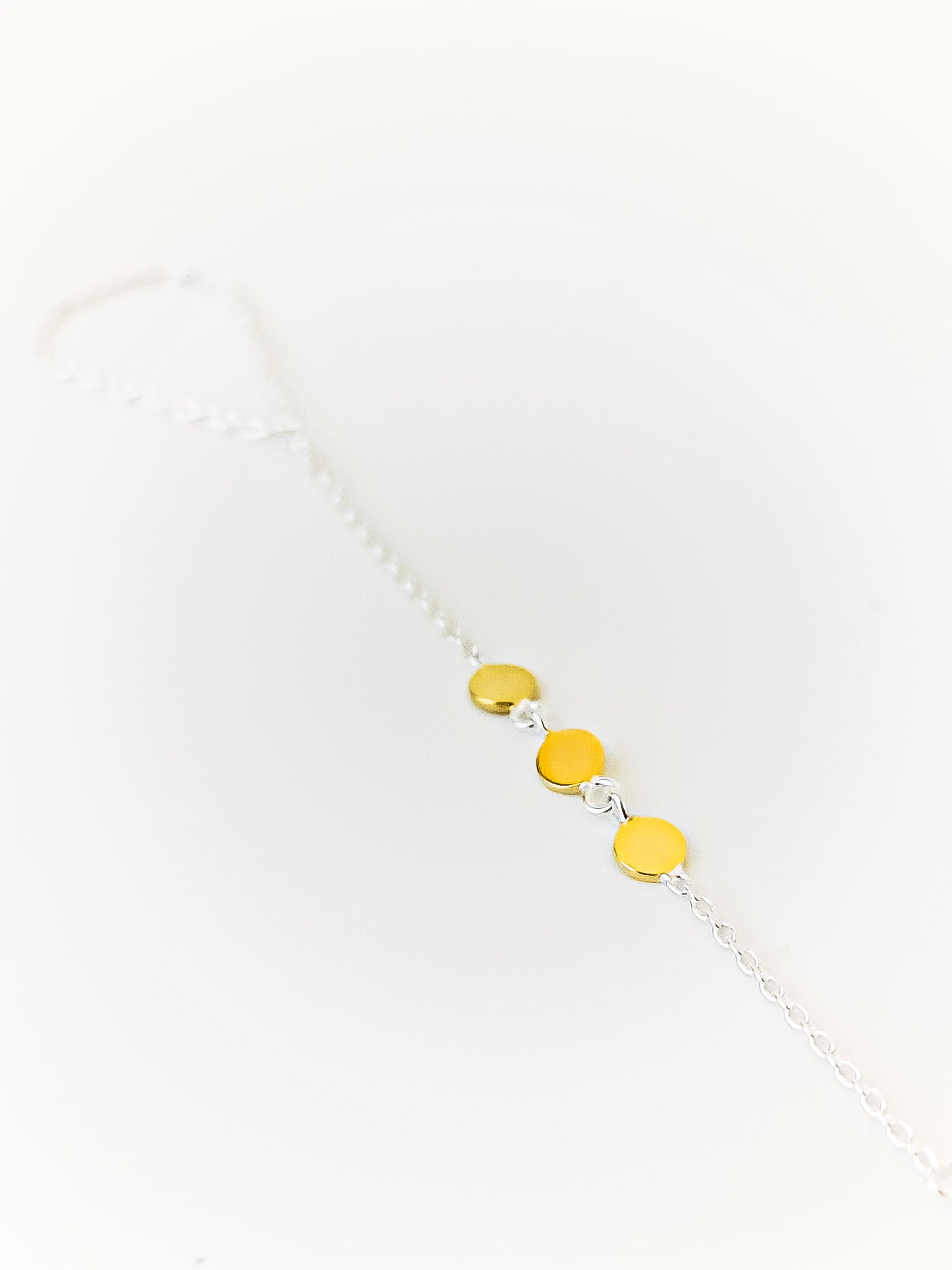 Bracelet with gold and silver beads on a white background