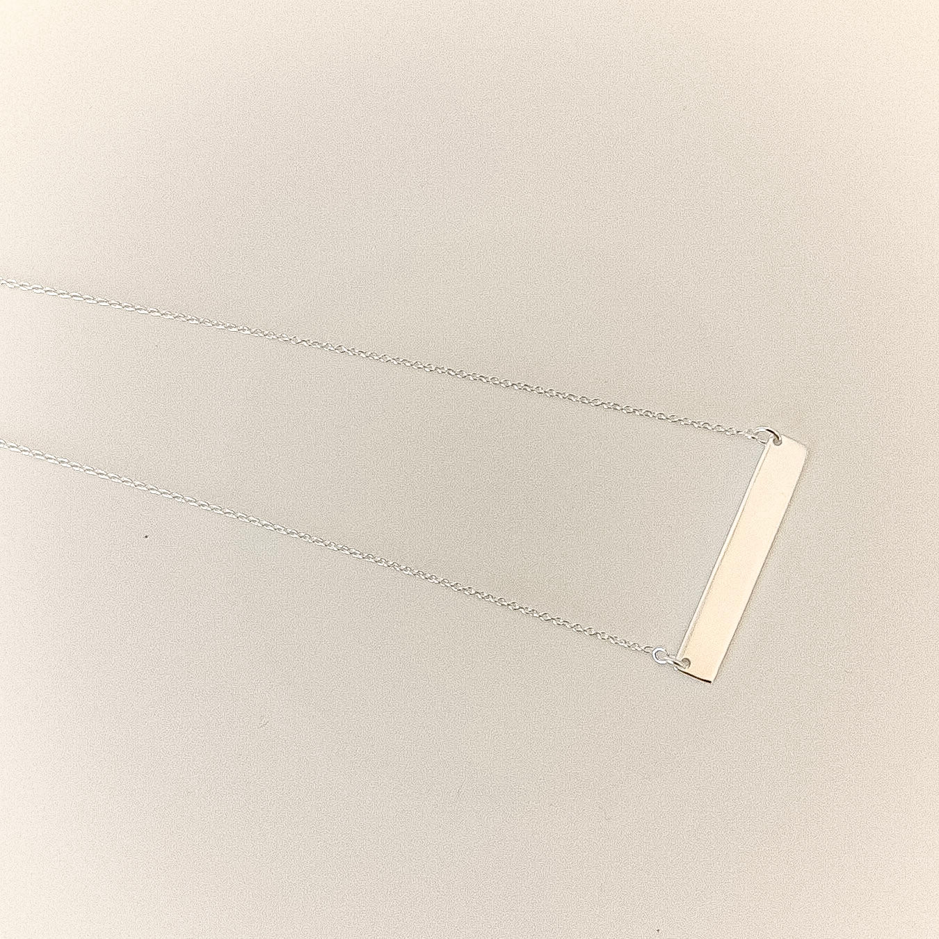 bar necklace on a beige background
