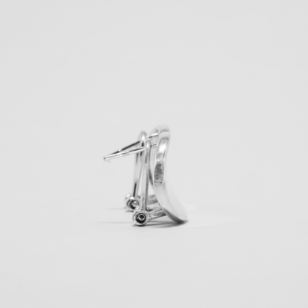 Silver earring on a light gray background