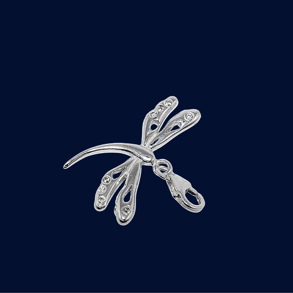 Silver dragonfly-shaped brooch on a dark blue background