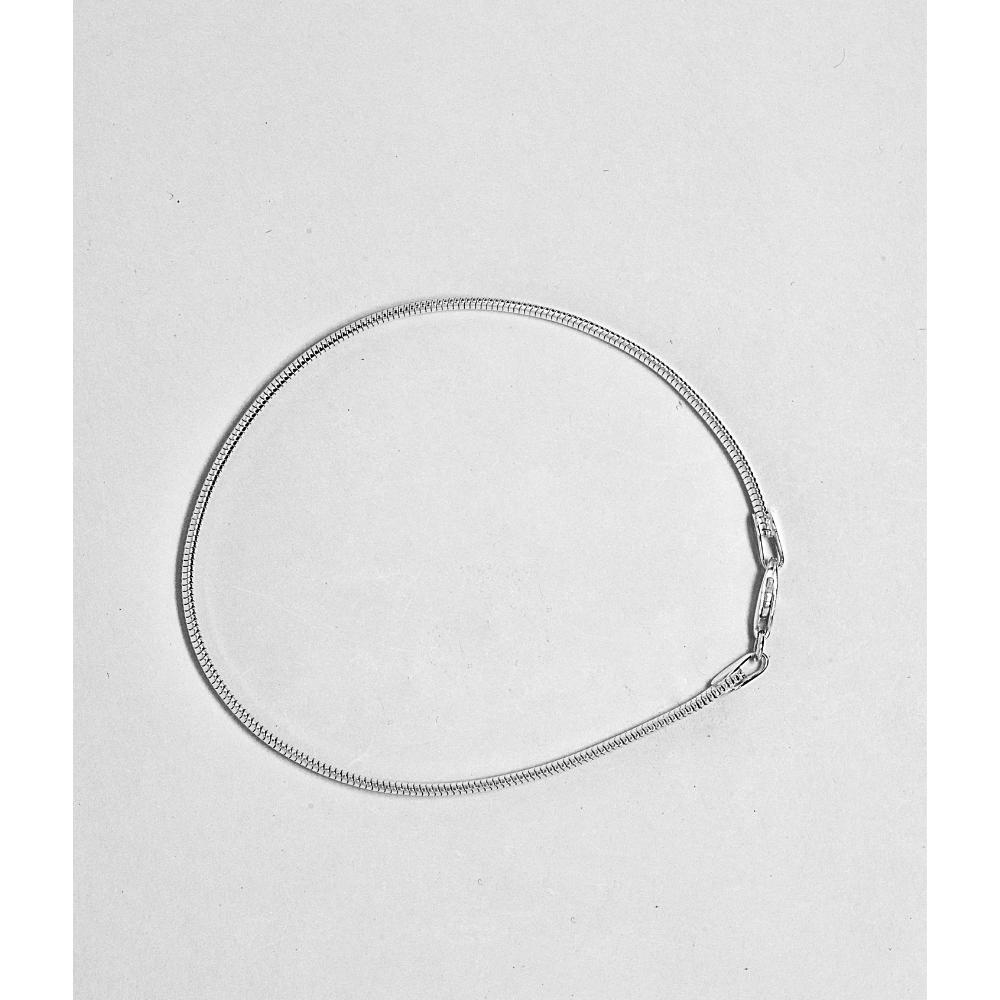 Silver snake chain necklace on a light grey background