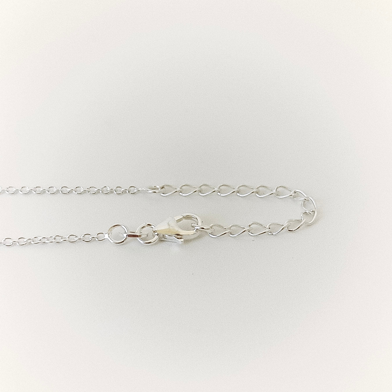 Silver chain bracelet on a light gray background