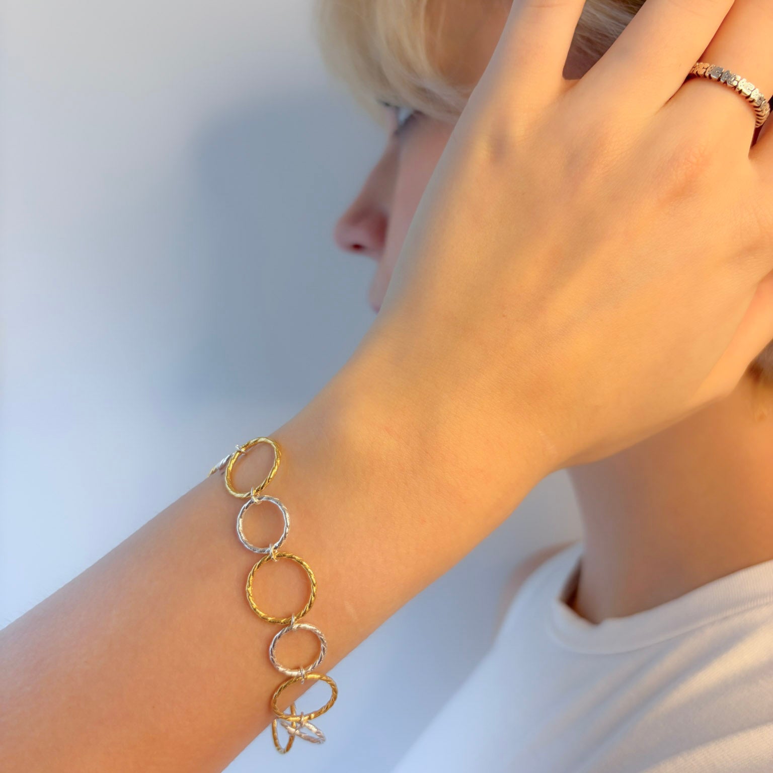 Gold chain bracelet on a person's wrist with a blurred background