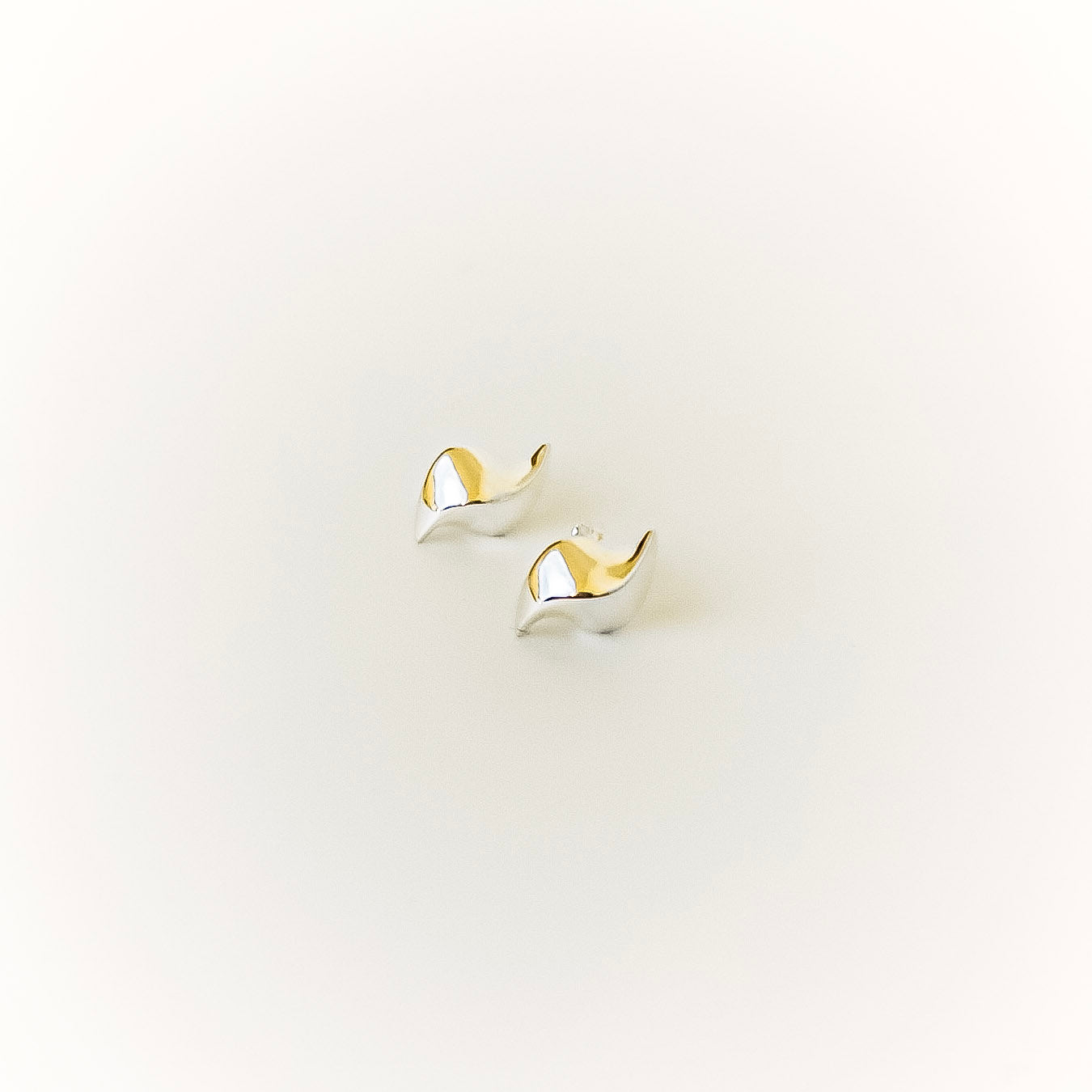 silver earrings on a light gray background