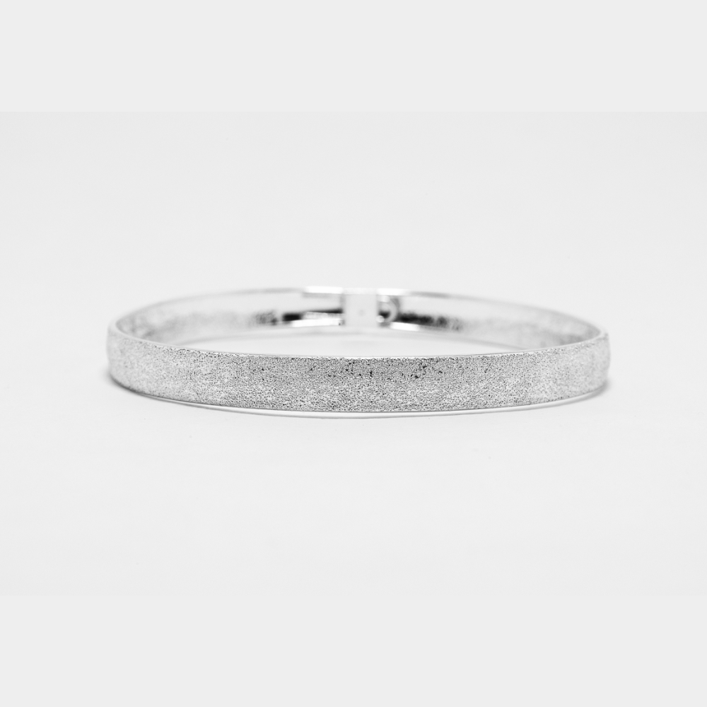 Silver ring with a textured band on a light gray background