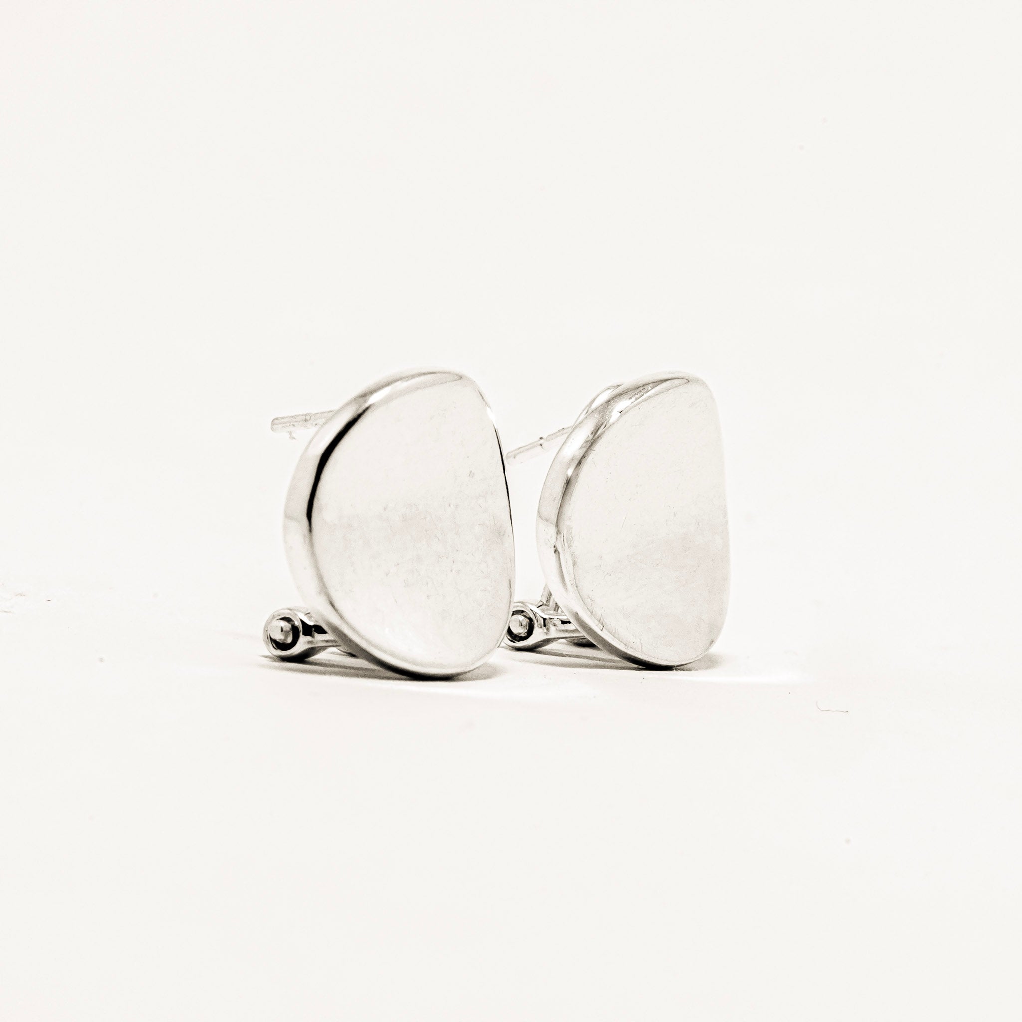 Pair of silver earrings on a light beige background