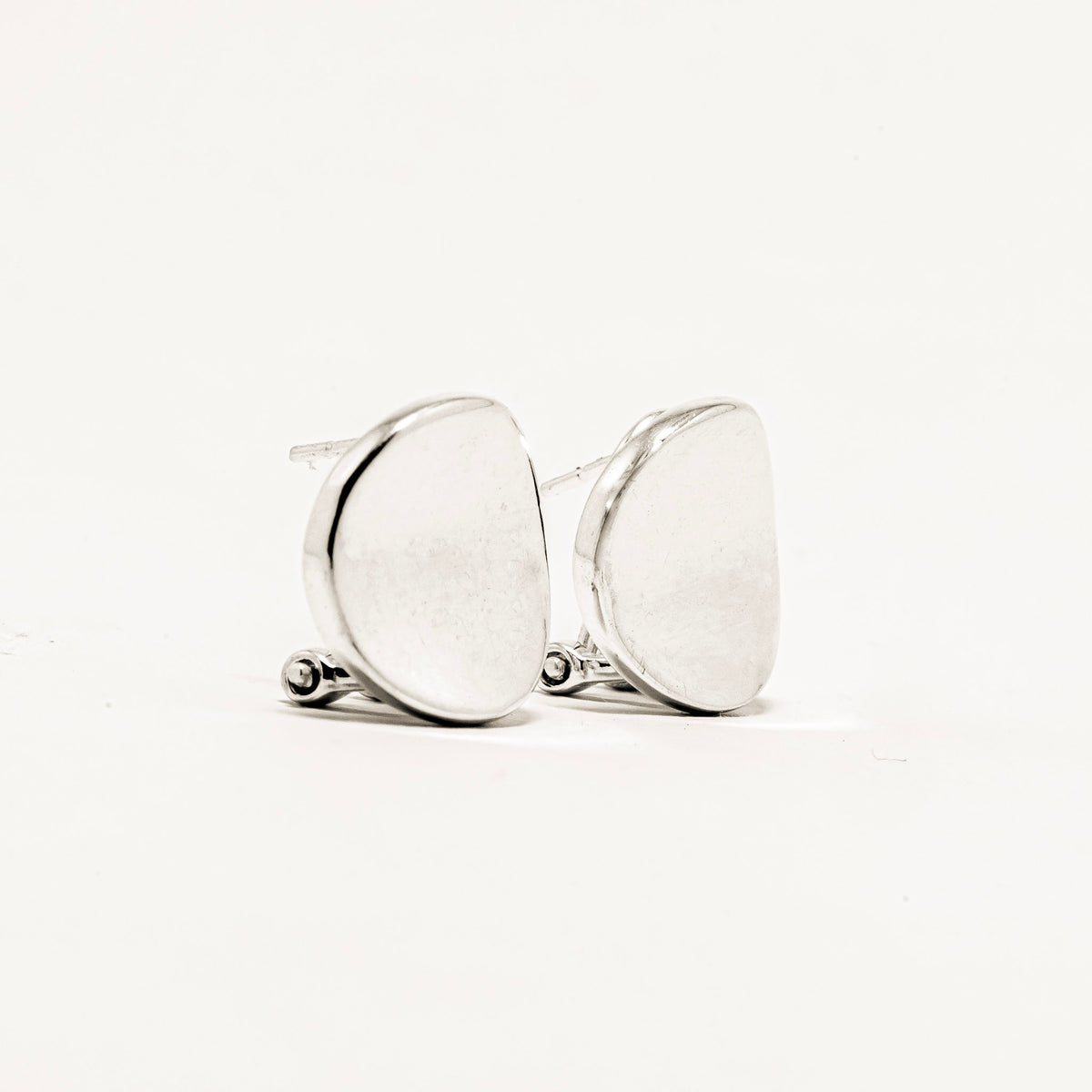 Pair of silver earrings on a light beige background