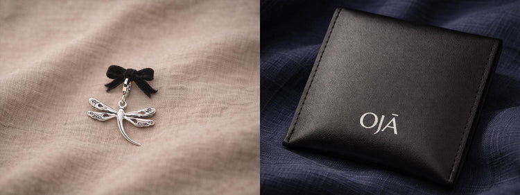 Silver dragonfly earring on a textured surface with a black box labeled 'OJ¤' in the background.